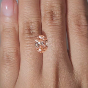 Close-up of 2.62ct Oval vivid pink diamond in warm ambient light