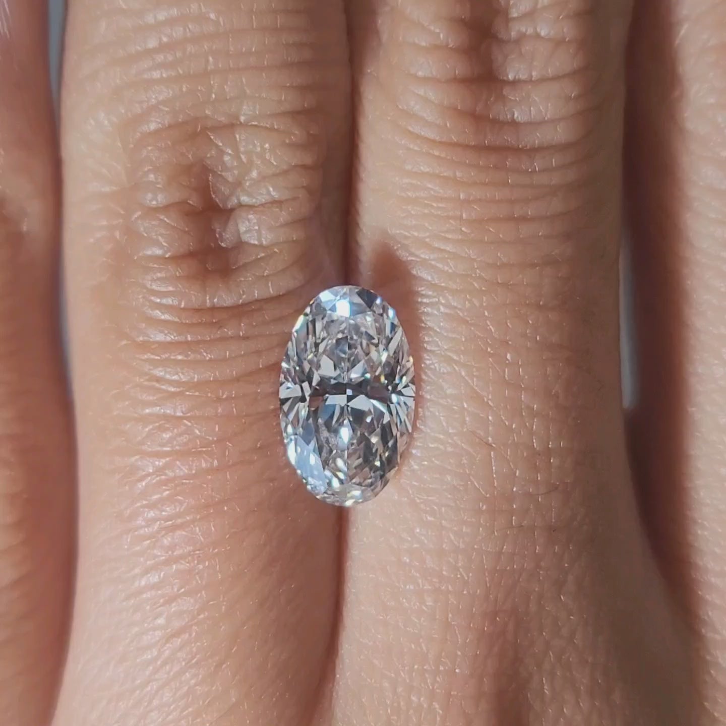 "Hand-modeled video of 2.252ct oval diamond in warm indoor lighting"