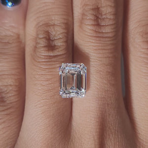 Hand-display video showing 5.025ct emerald cut diamond in warm home lighting