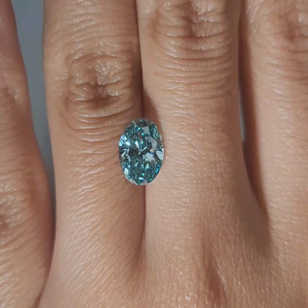 "Hand-modeled video of 1.861ct blue oval diamond in warm indoor lighting"