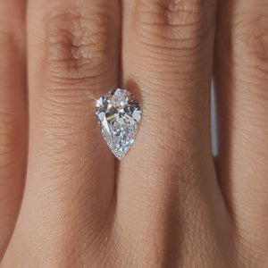 "Close-up hand video of 1.92ct pear lab diamond in warm indoor lighting"