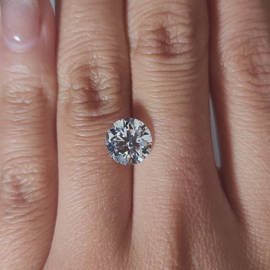 "Hand-modeled video of 2.402ct round diamond in warm indoor lighting"