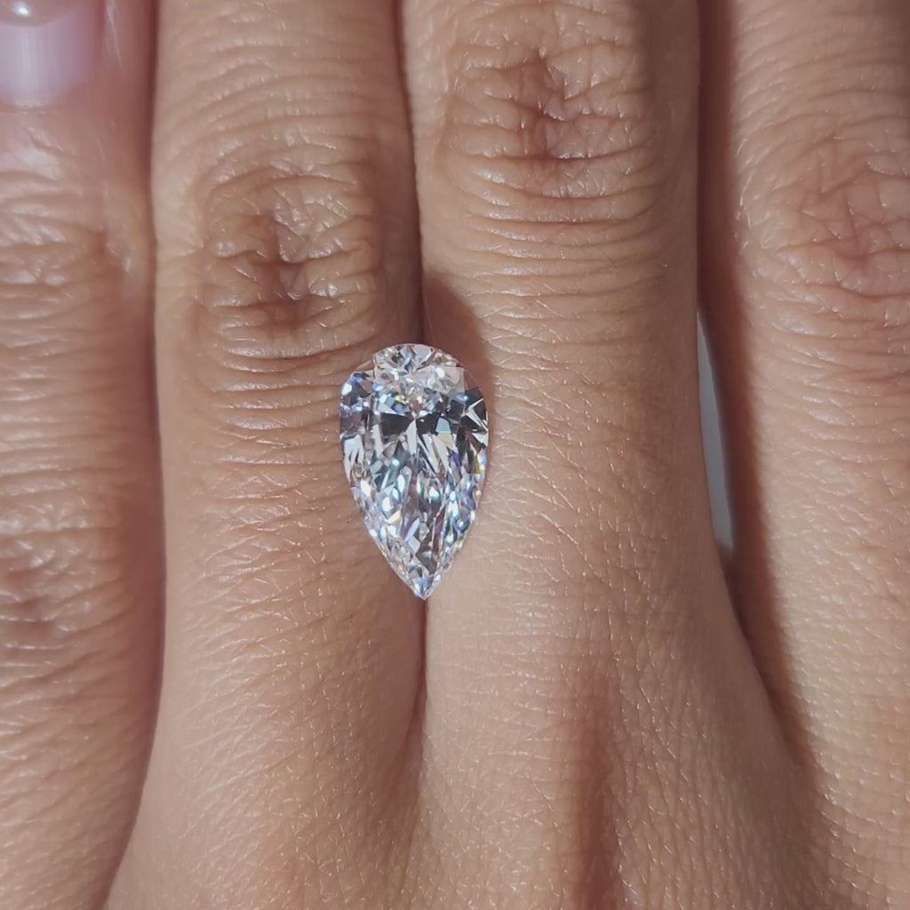 "Hand-modeled video of 3.137ct pear diamond in warm indoor lighting"