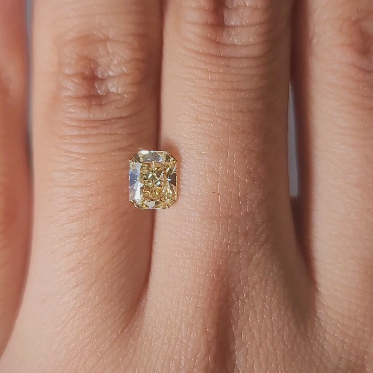 "Hand-worn video of 1.00ct yellow radiant diamond under jewelry store lighting"