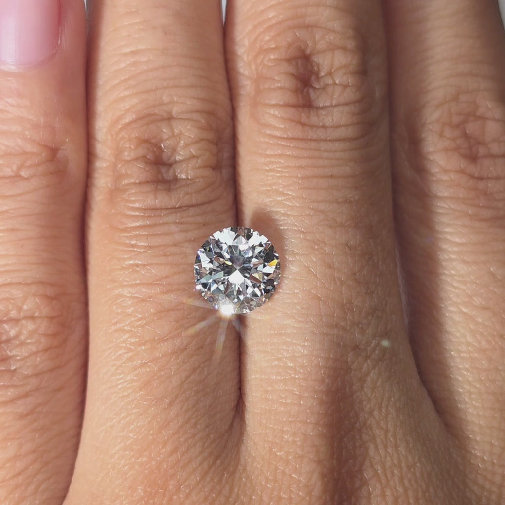 Hand showcasing a 2.10ct Crown Arrow Cut™ D color lab diamond indoors.