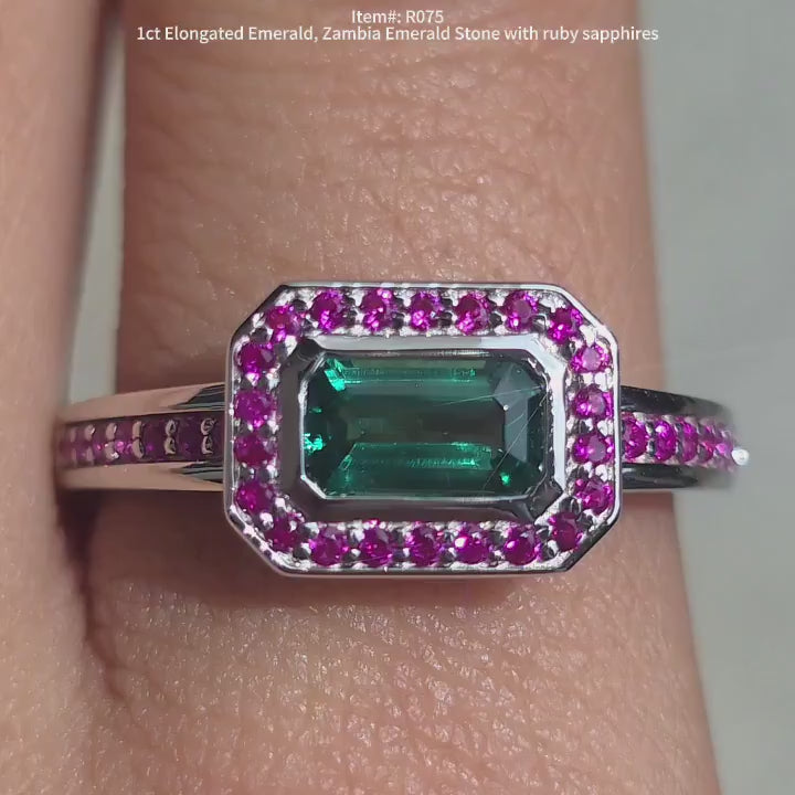 DovEggs zambia emerald with halo rubby sapphires engagement ring in sunlight