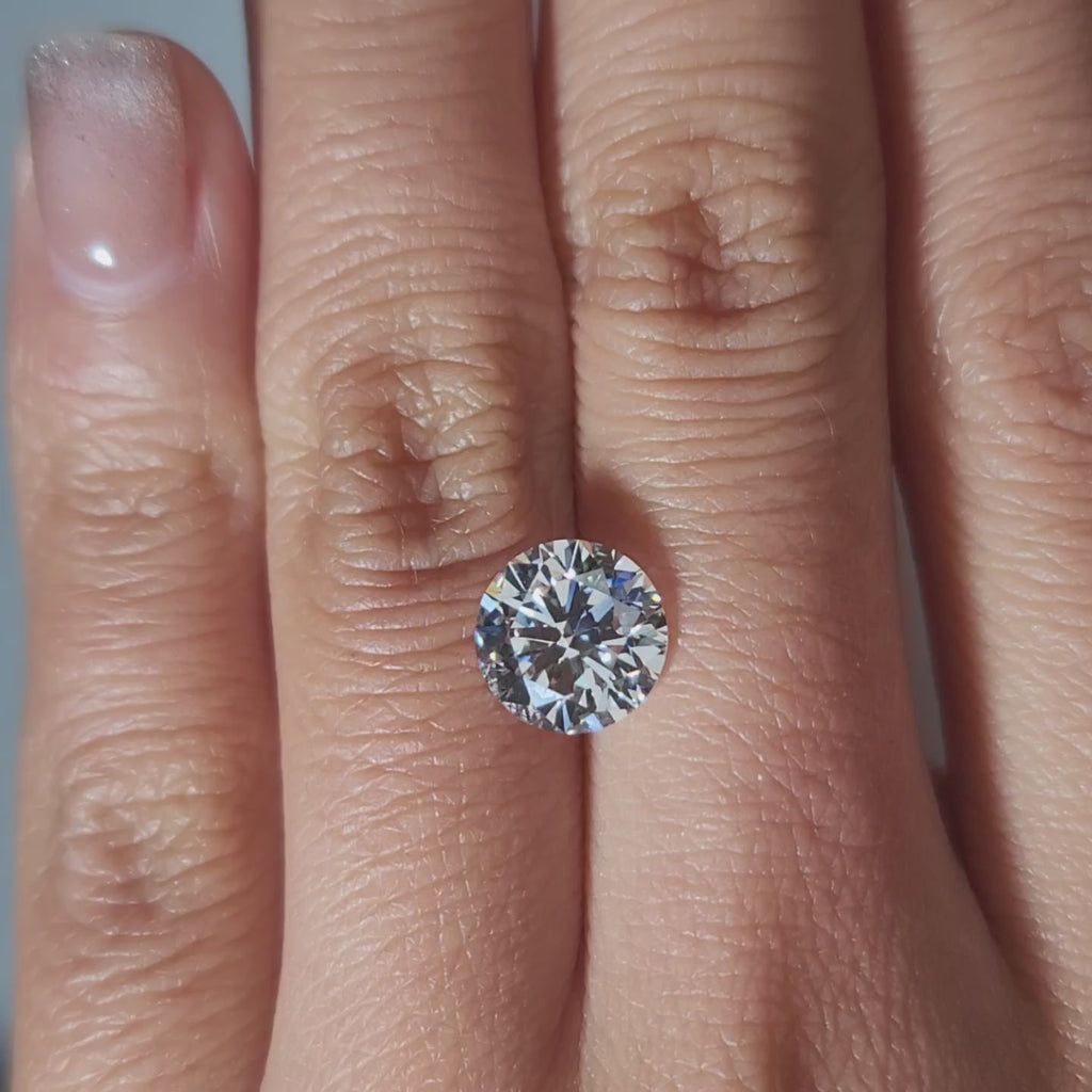 "Hand-modeled video of 2.445ct round diamond in warm indoor lighting"
