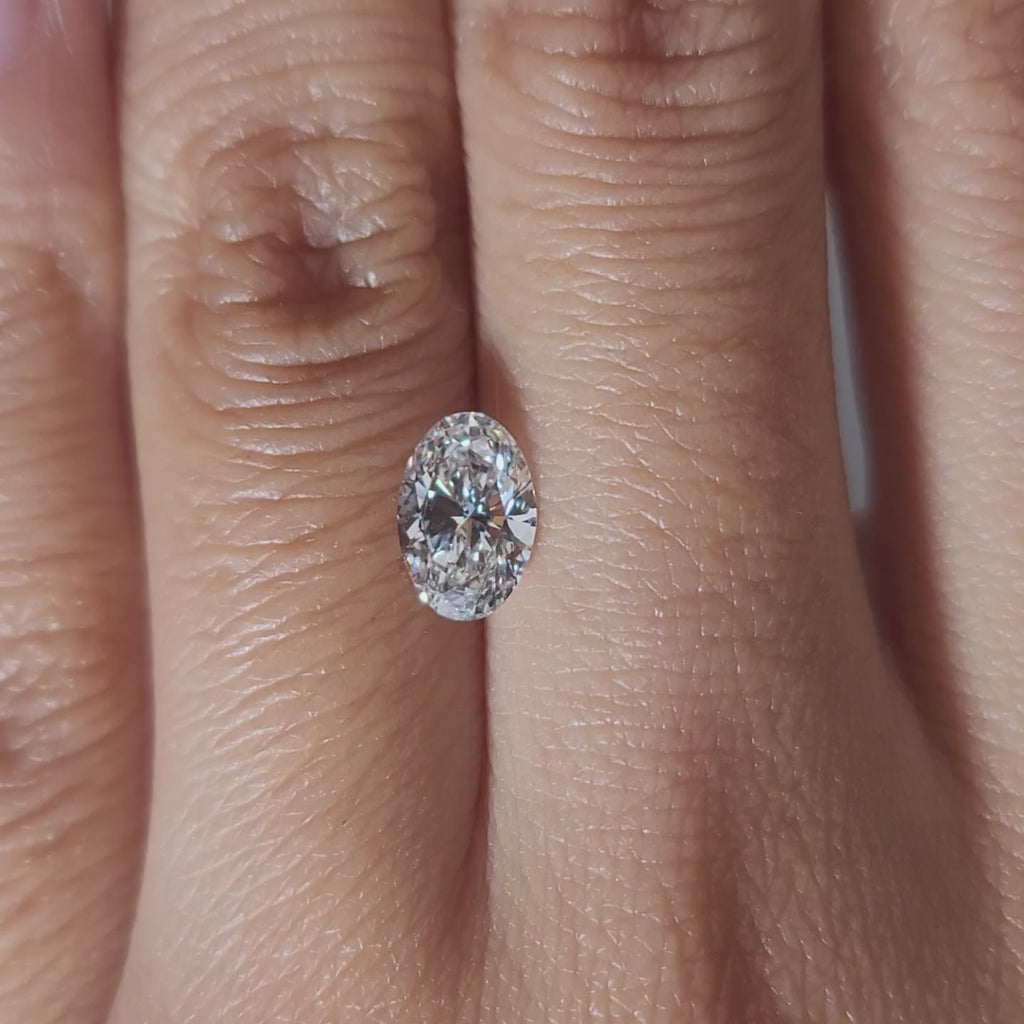 "Hand-modeled video of 1.01ct oval diamond in warm indoor lighting"