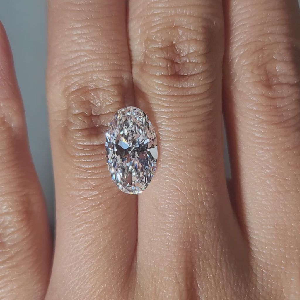 "Hand-modeled video of 4.502ct oval diamond in warm indoor lighting"