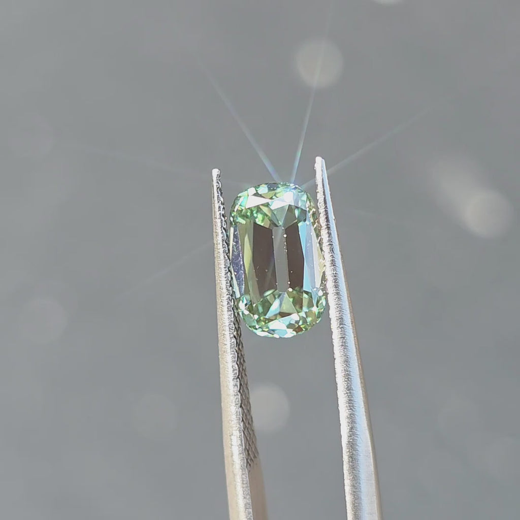 2.19ct cushion old mine cut fancy vivid green VS1 lab diamond sparkling under outdoor sunlight.