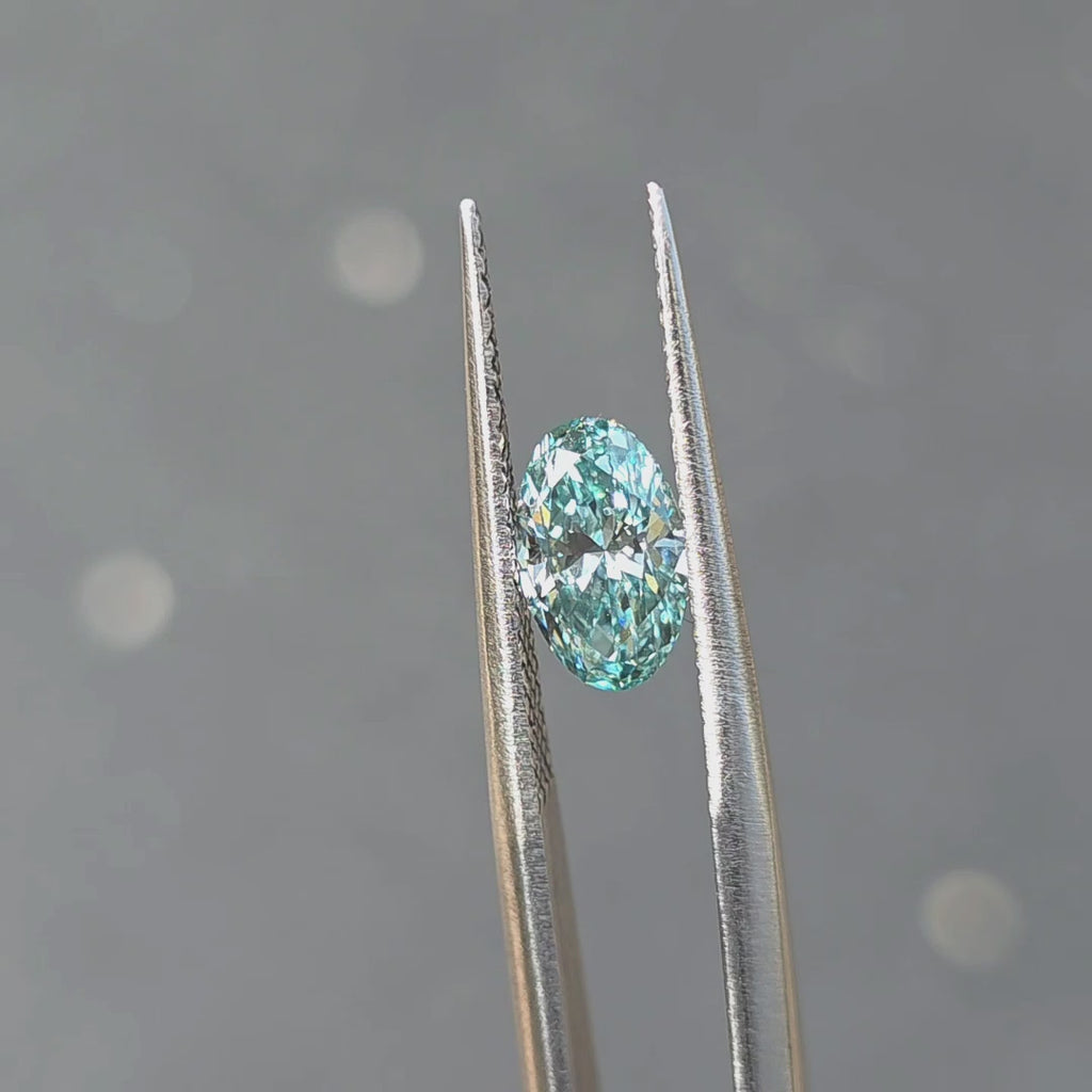 Sunlight showcases the vibrant blue of a 1.06ct oval brilliant cut fancy vivid blue lab diamond.