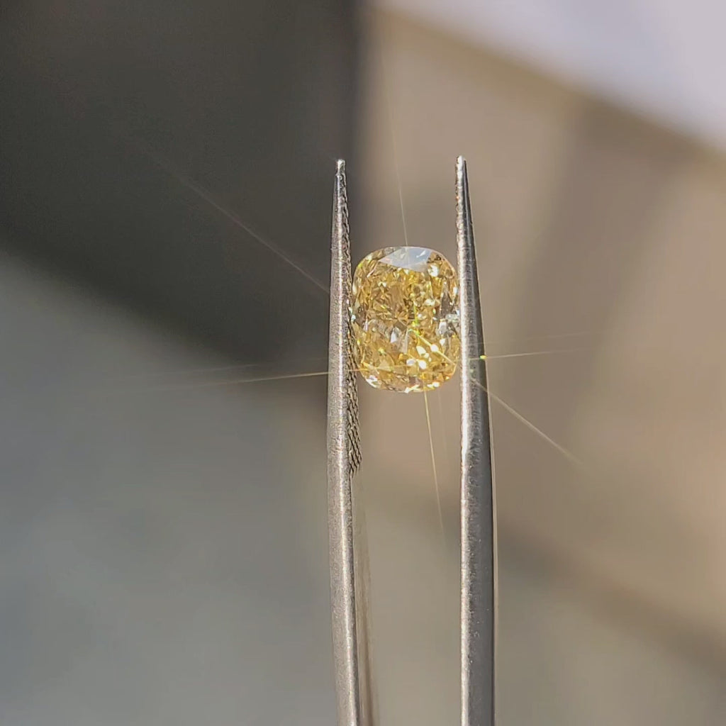 2.4ct cushion cut fancy vivid yellow diamond in sunlight showing intense color and brilliance