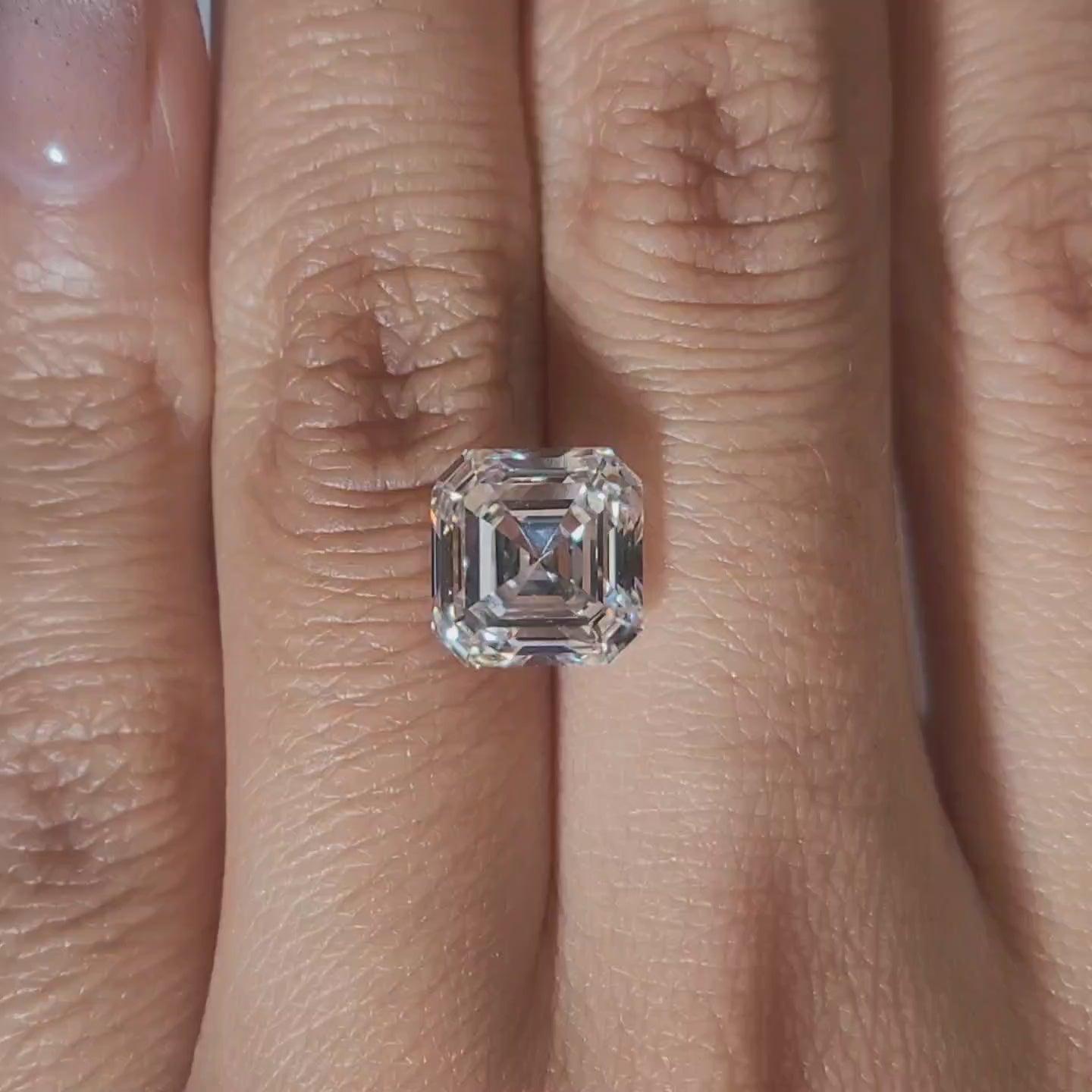 "Hand-modeled video of 4.038ct asscher diamond in warm indoor lighting"