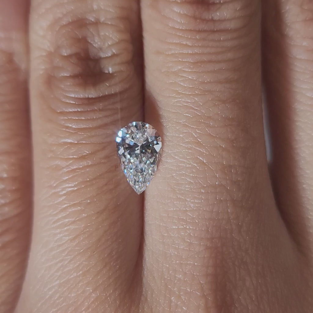 "Hand-modeled video of 1.00ct pear diamond in warm indoor lighting"