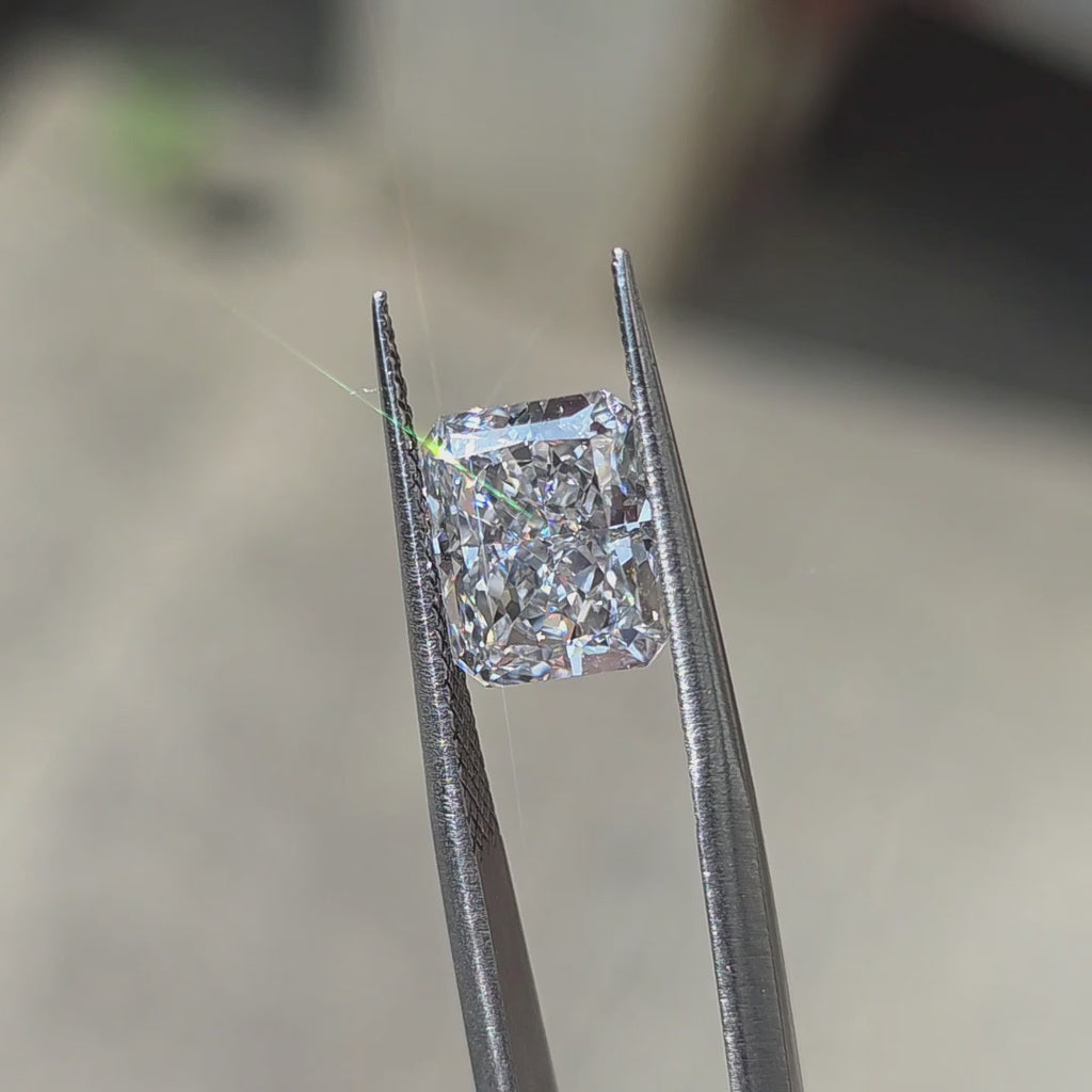 A 3.65ct radiant brilliant cut lab diamond sparkling in outdoor sunlight.
