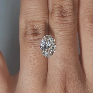 Finger-modeled video of 2.73ct oval diamond under warm indoor light
