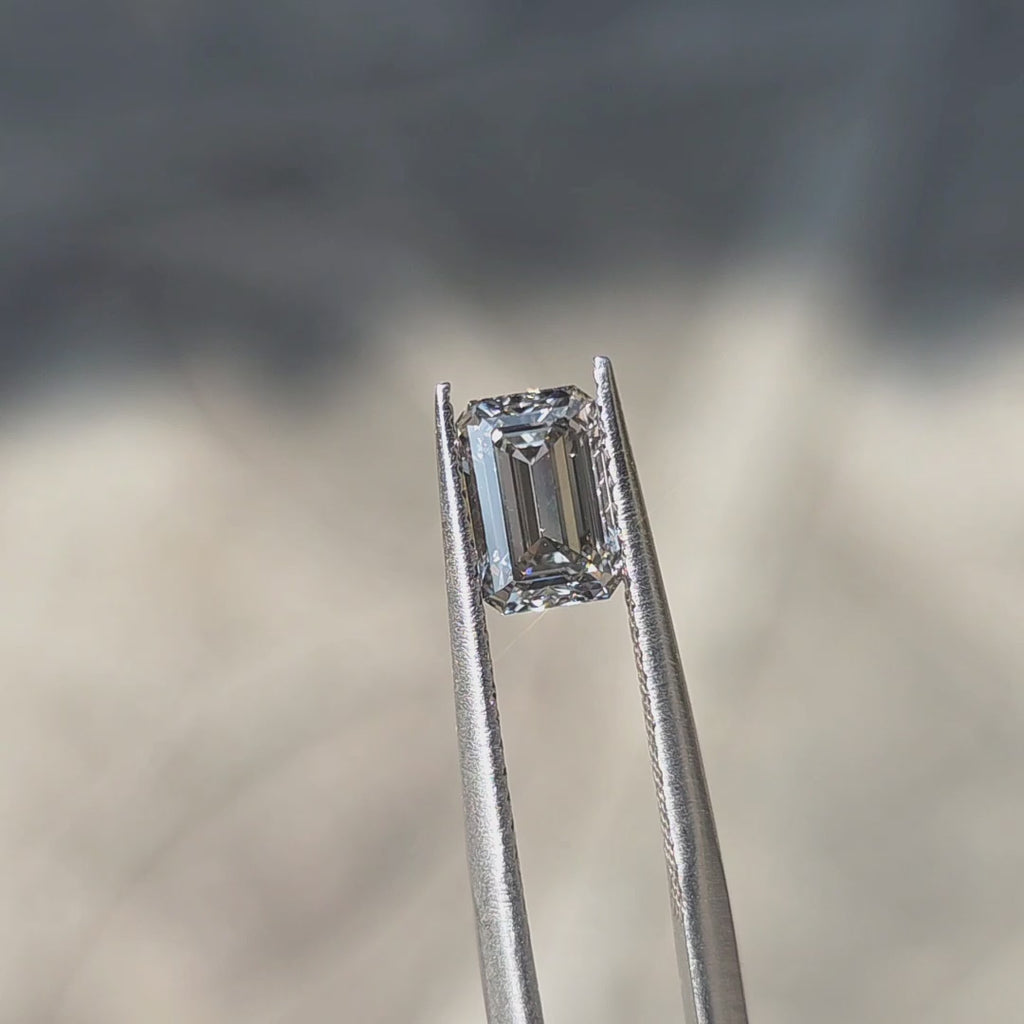 1.24ct emerald cut fancy gray VS1 lab diamond displaying sophisticated gray tone in outdoor sunlight.