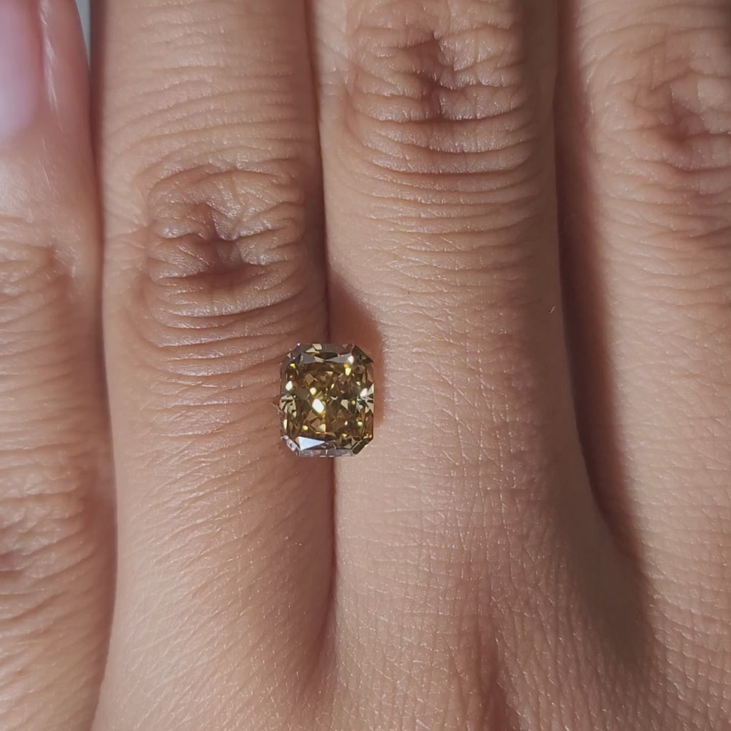 Close-up hand video of 1.420ct brown radiant diamond in warmlight