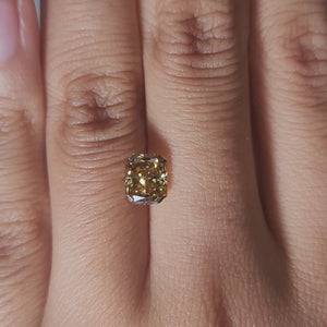 Close-up hand video of 1.420ct brown radiant diamond in warmlight