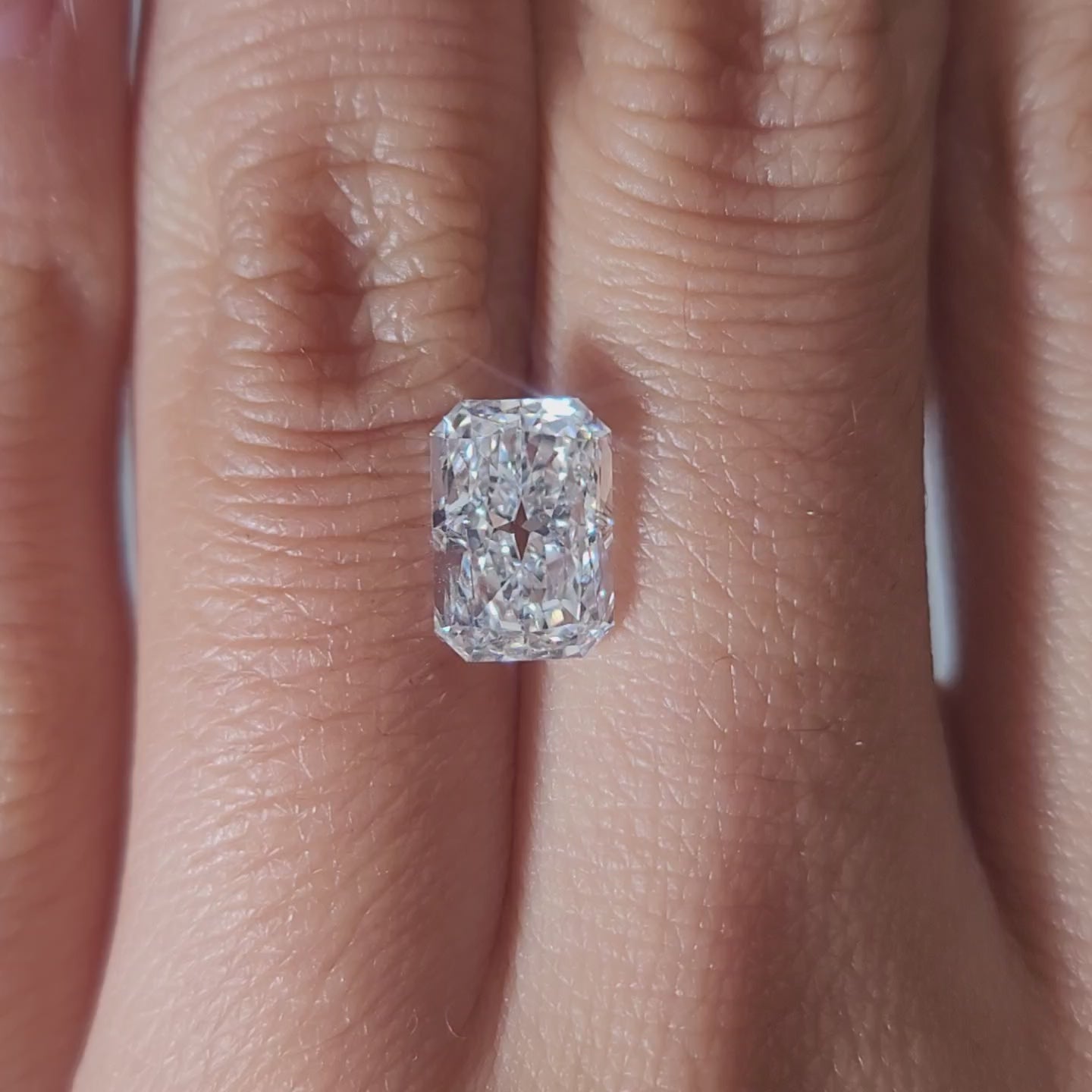"Hand-modeled video of 2.178ct radiant diamond in warm indoor lighting"
