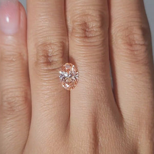 Handheld video of 1.71ct Oval vivid pink diamond in warm ambient light