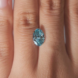 Hand-modeled video of 2.03ct fancy vivid greenish blue oval diamond in warm indoor light
