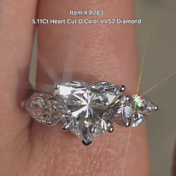 DovEggs Three Stones style 5ct Heart lab grown diamond engagement ring sparkling in sunlight video.