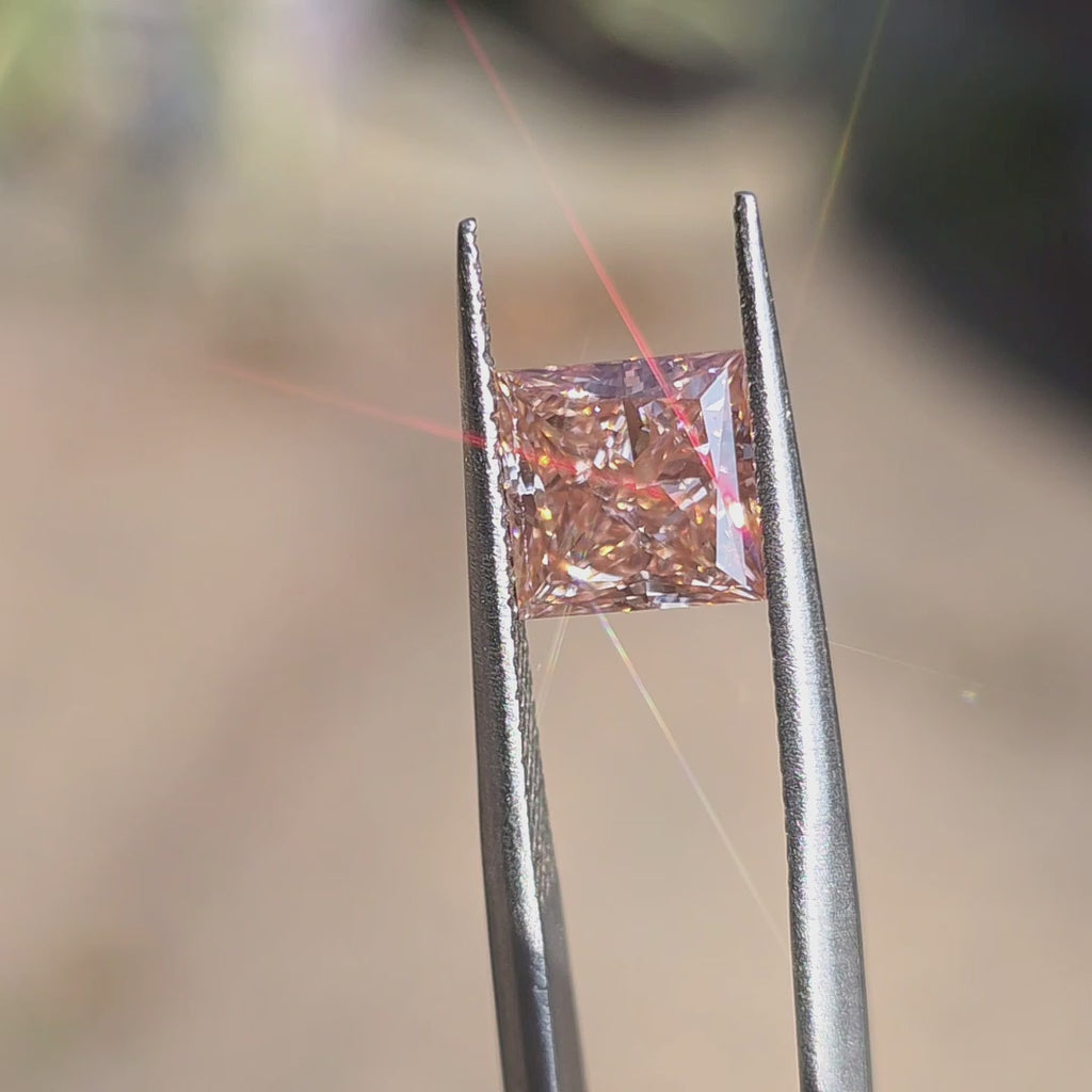 2.08ct princess brilliant cut fancy vivid pink VS1 lab diamond displaying modern square brilliance in outdoor sunlight.