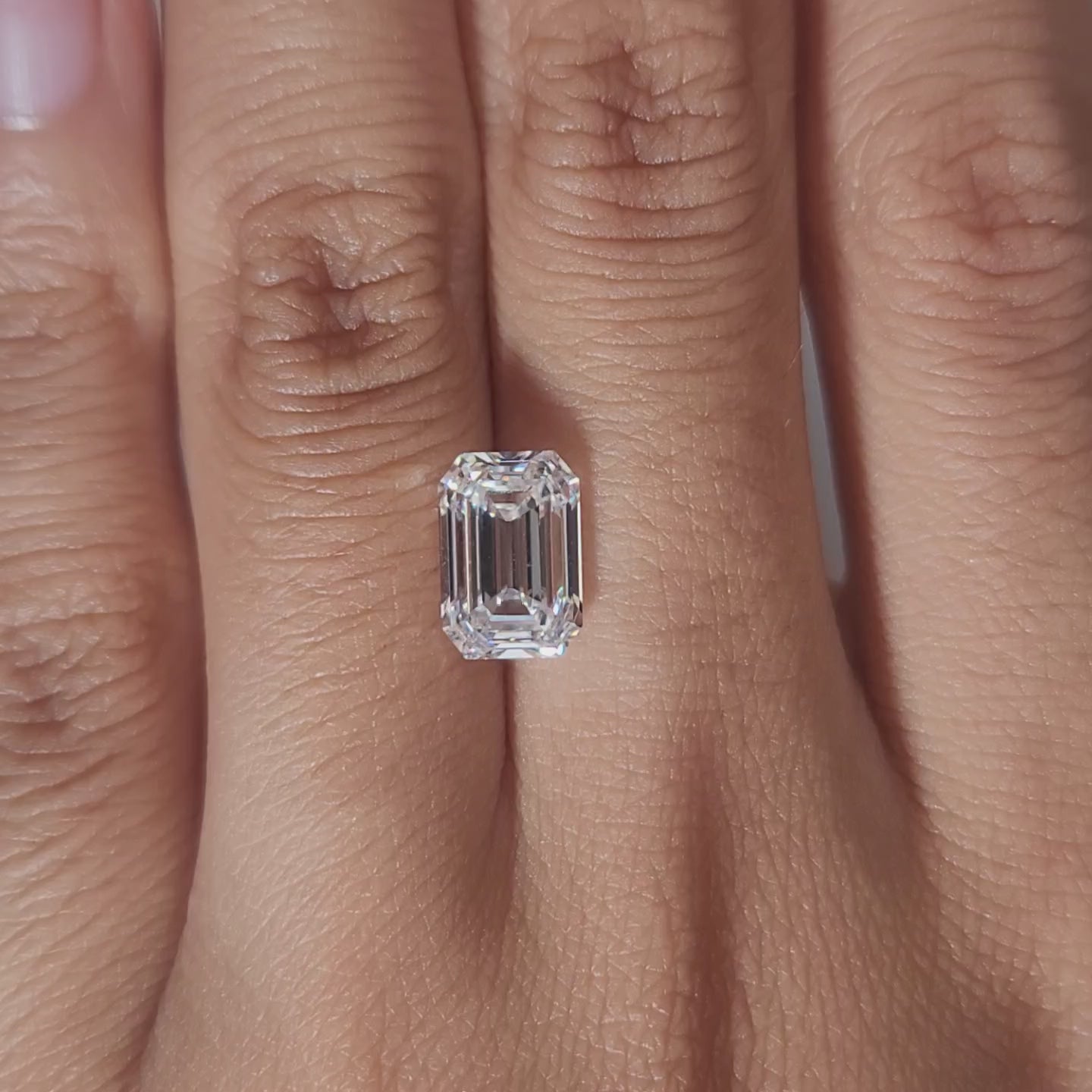Hand-modeled video of 2.682ct emerald cut diamond in warm indoor lighting