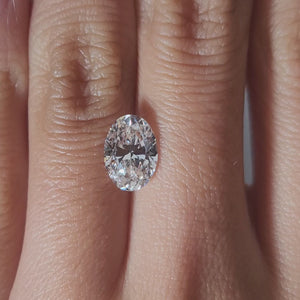 "Hand-modeled video of 1.902ct oval diamond in warm indoor lighting"