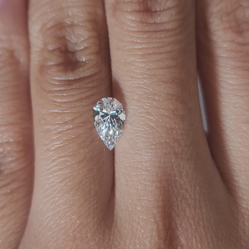 "Hand-modeled video of 1.01ct pear diamond in warm indoor lighting"