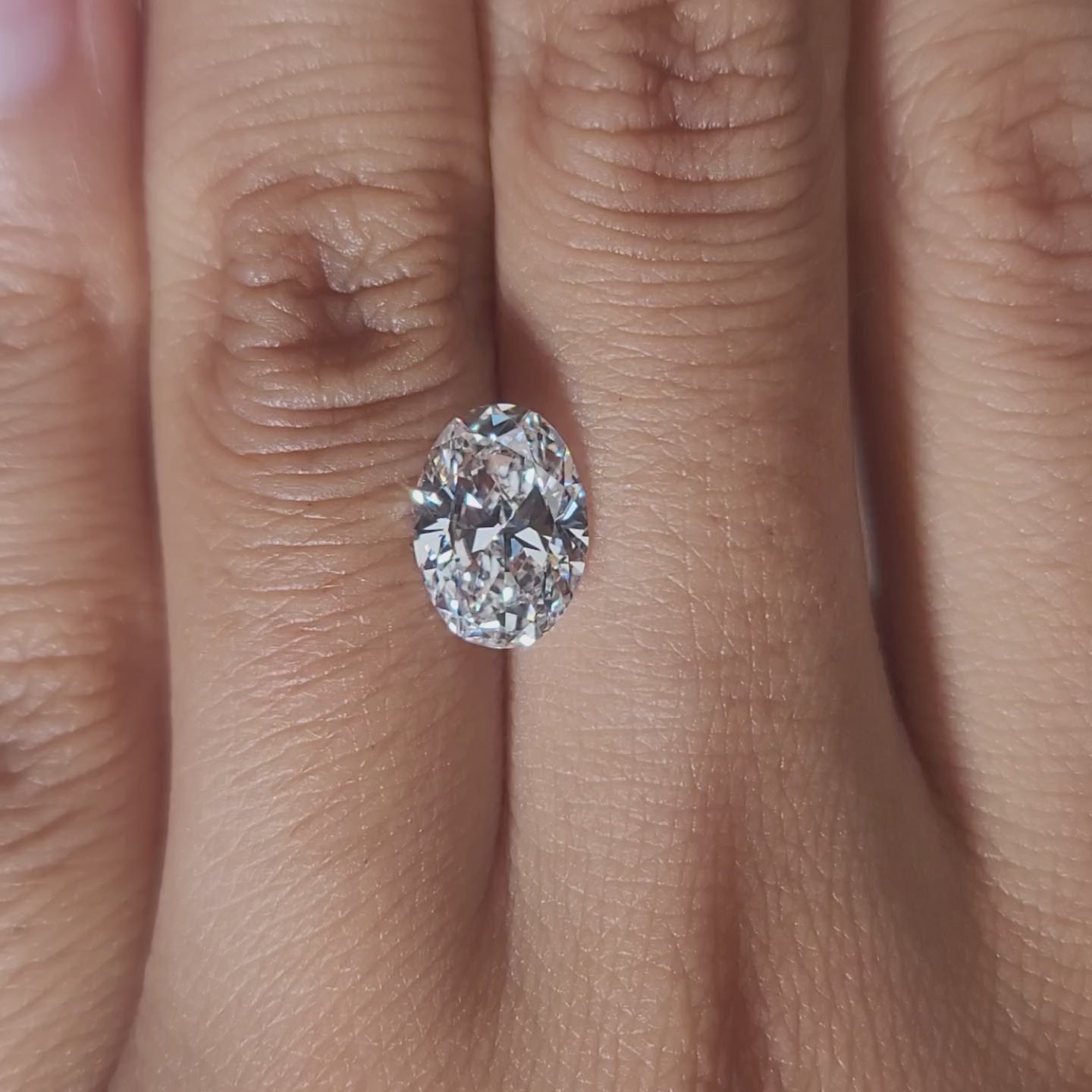 Hand-worn video of 2.021ct oval diamond in warm lighting
