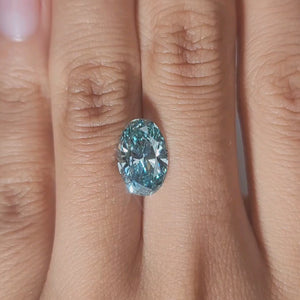 Hand-display video of 3.200ct blue oval diamond under warm interior light