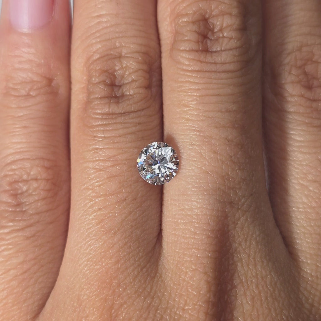 Hand modeling a 1.07ct Crown Arrow Cut™ lab diamond in warm indoor light.
