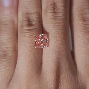 Hand-modeled video of 2.41ct vivid pink princess diamond under warm lighting
