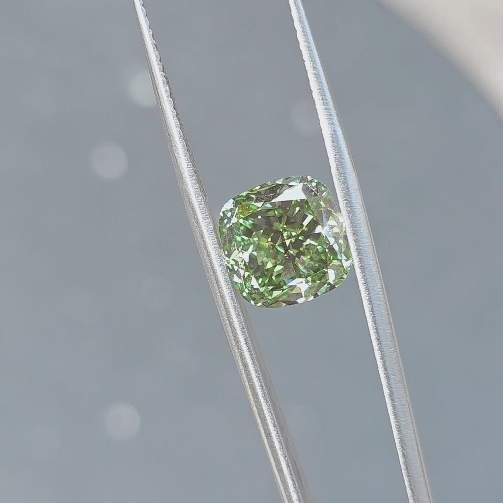 A 6.68ct cushion brilliant cut fancy vivid green VVS1 lab diamond sparkles in outdoor sunlight.