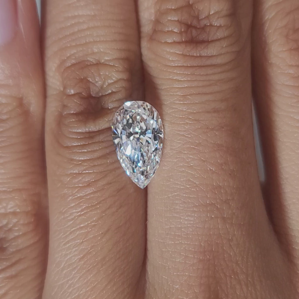 "Hand-modeled video of 2.398ct pear diamond in warm indoor lighting"