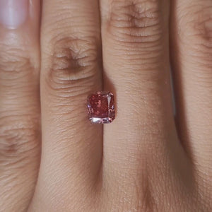 Hand-modeled video of 1.540ct radiant pink diamond in warm indoor lightin