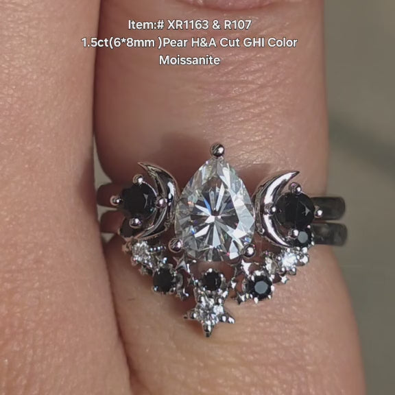 DovEggs Pear moissanite ring stack with star curved wedding band sparkling in sunlight video.