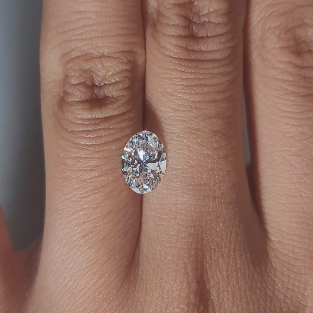 Hand-modeled video of 1.50ct oval D color diamond in warm indoor lighting