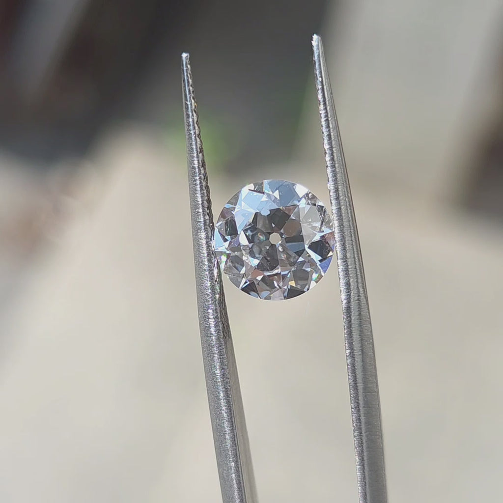 2.10ct round European cut E color VVS1 lab diamond displaying vintage sparkle in outdoor sunlight.