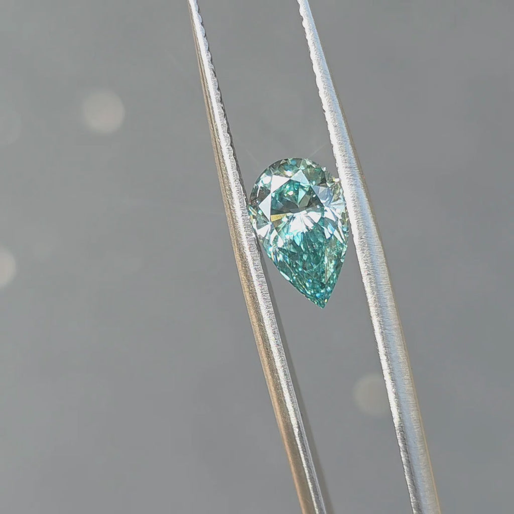 A 2.05ct pear brilliant cut fancy vivid blue lab diamond sparkles in outdoor sunlight.