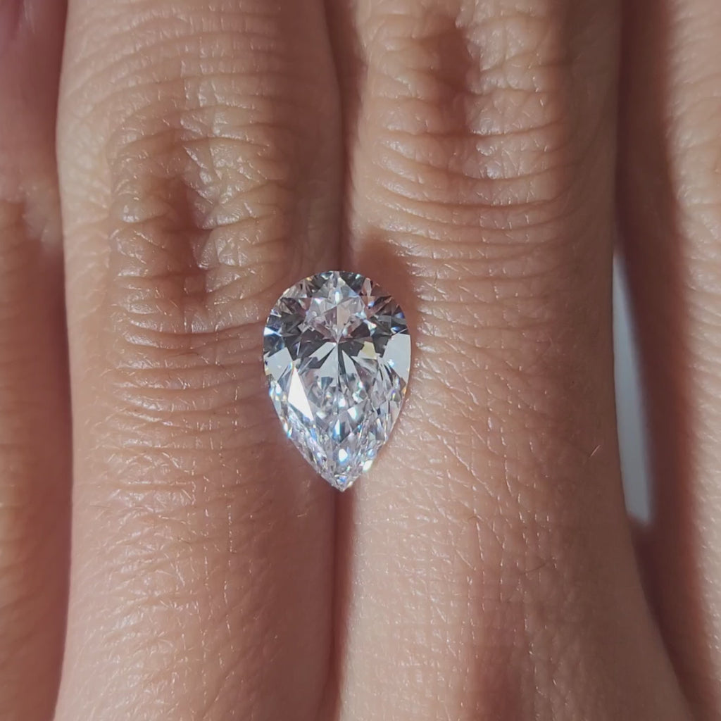 "Hand-modeled video of 2.228ct pear diamond in warm indoor lighting"