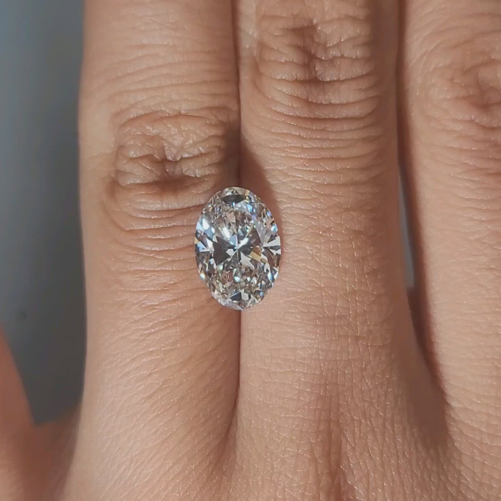 Hand-display video showing 2.70ct oval diamond in warm home lighting