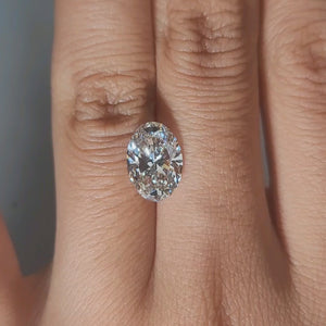 Hand-display video showing 2.70ct oval diamond in warm home lighting