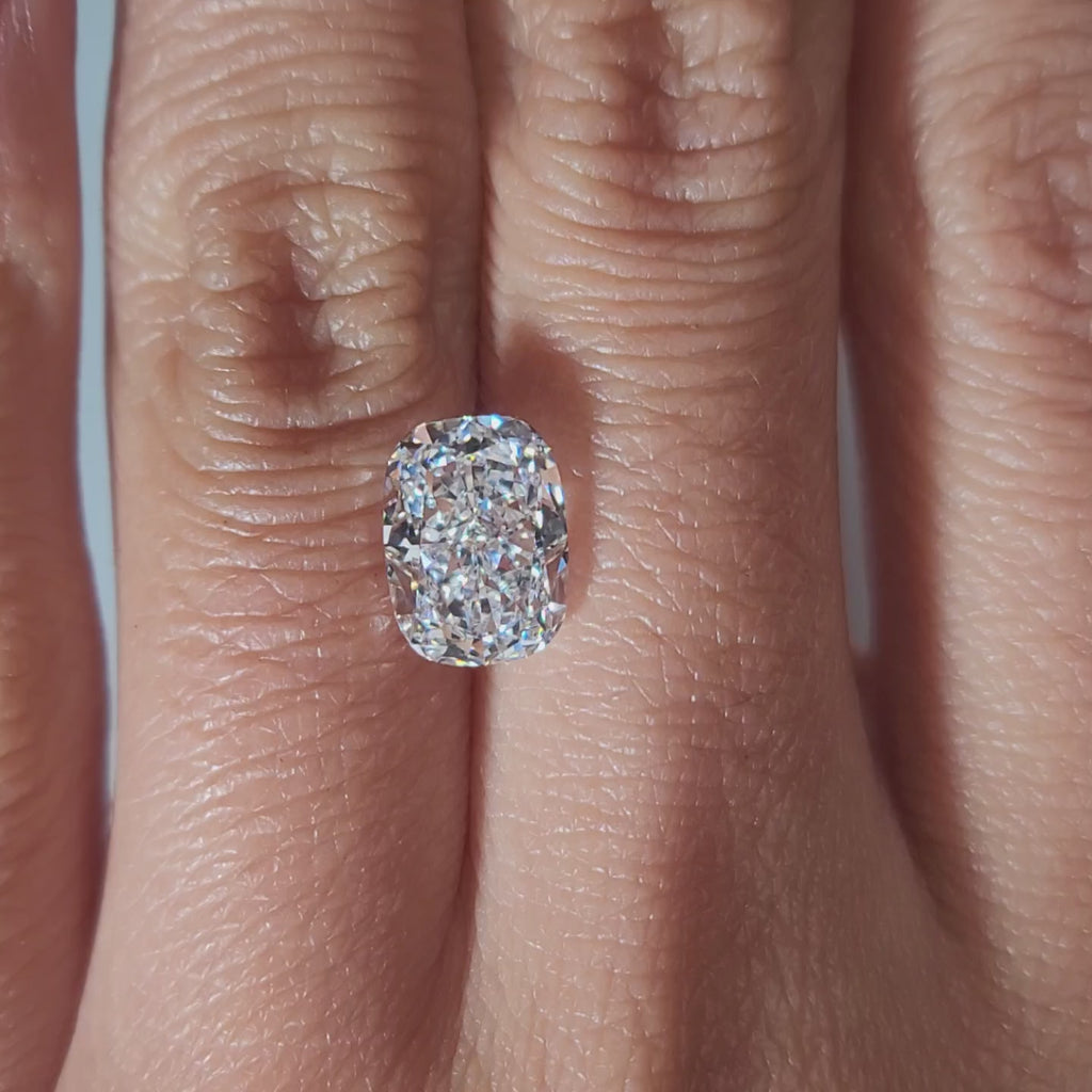 "Hand-modeled video of 2.608ct cushion diamond in warm indoor lighting"
