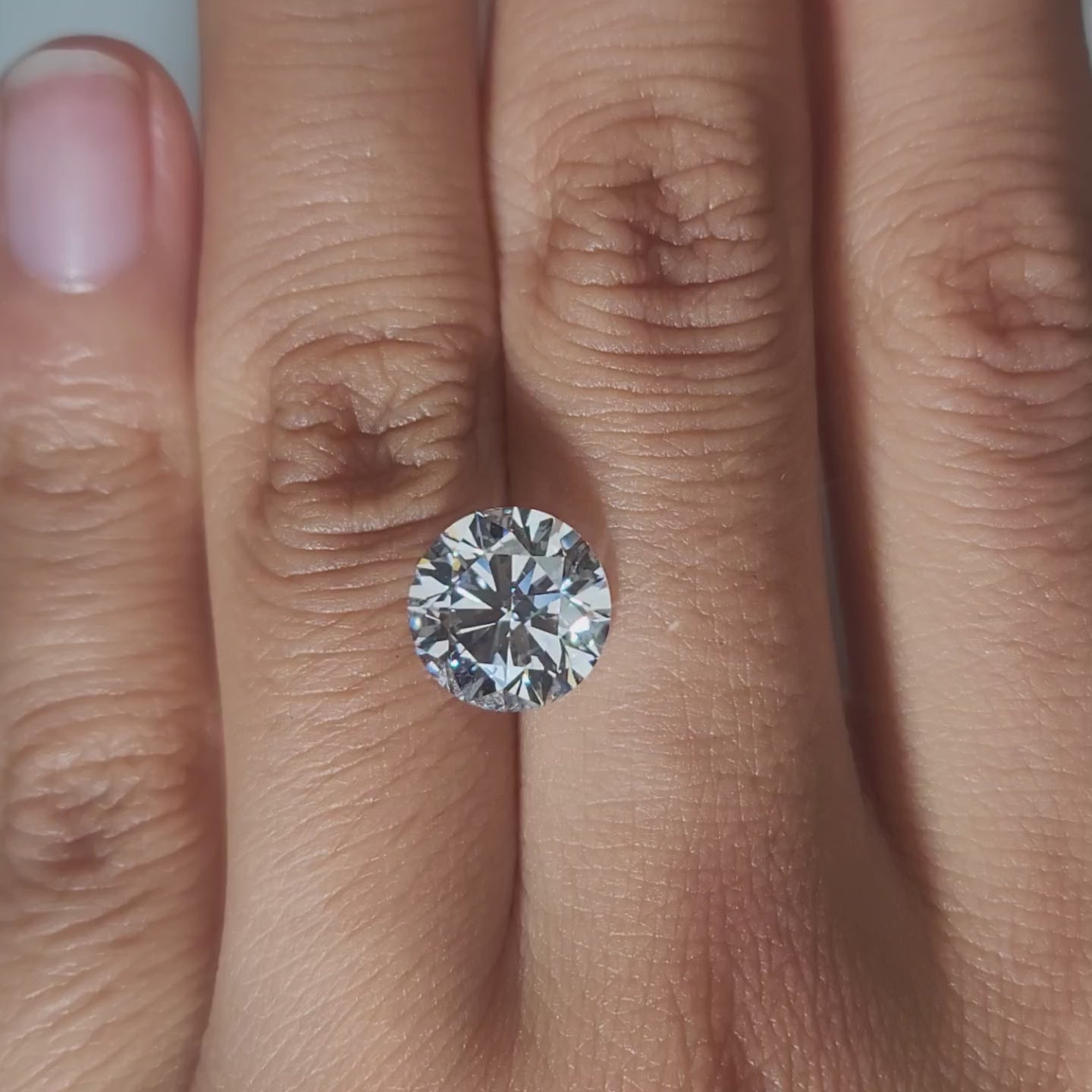 Hand-modeled video of 3.35ct round diamond in warm indoor lighting