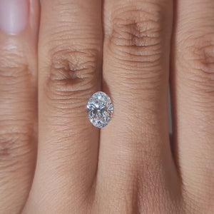 Hand-modeled close-up of 1.03ct oval diamond in warm glow