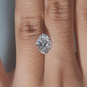 Close-up hand video displaying 1.87ct oval diamond in cozy indoor light