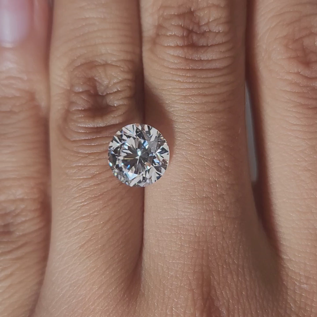 Close-up hand video of 3.013ct round diamond in soft indoor lighting